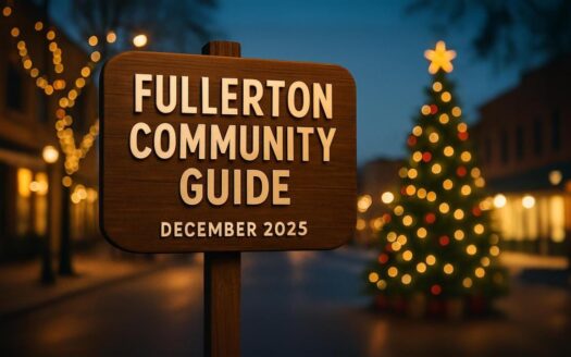 Wooden sign reading “Fullerton Community Guide — December 2025” on a festive downtown street at dusk, with holiday lights and a decorated tree in the background.